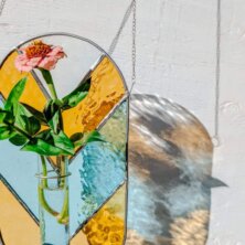 Stained Glass vase with a pink flower in it
