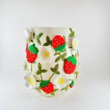 Painted mug with strawberry and flower motif.