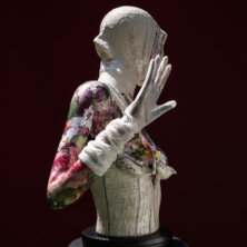 Sculpture of a woman on black background.