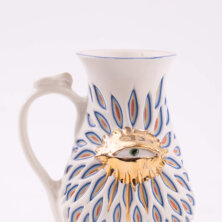 White vase with a realistic eye drawn in the middle.