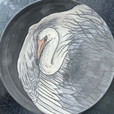 Black plate with white heron on it.
